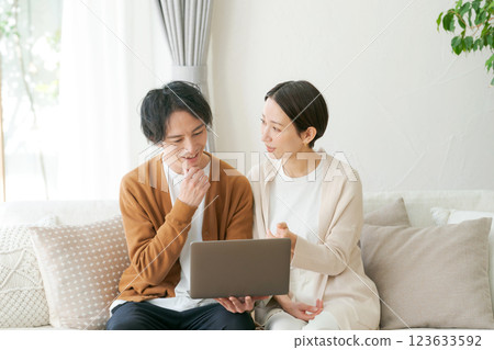 一對夫婦坐在沙發上看電腦 123633592