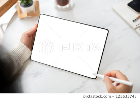 The left hand holding blank screen tablet and stylus pencil in right hand. Study or Working in cafe The left hand holding blank screen tablet and stylus pencil in right hand. Study or Working in cafe 123633745