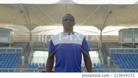 Front view of an African American male field hockey player, wearing a blue team strip, walking towar Front view of an African American male field hockey player, wearing a blue team strip, walking towar 123634151