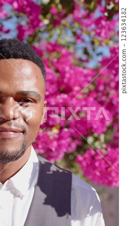 Vertical image of portrait of happy african american man looking at camera and smiling 123634182