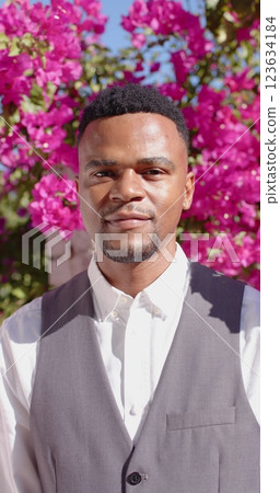 Vertical image of portrait of happy african american man looking at camera and smiling 123634184