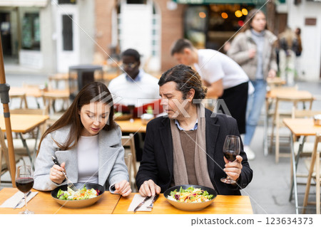 European couple sitting on the terrace of the restaurant and chatting 123634373