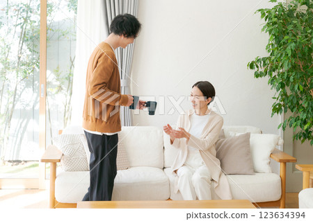A couple drinking coffee in the living room A couple drinking coffee in the living room 123634394
