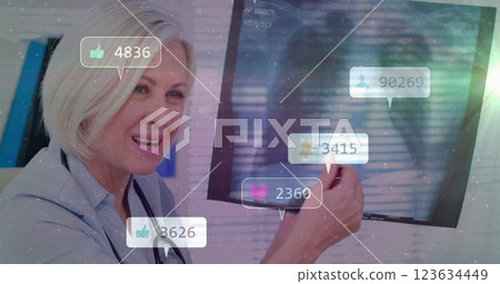 Social media engagement image over smiling doctor pointing at screen Social media engagement image over smiling doctor pointing at screen 123634449