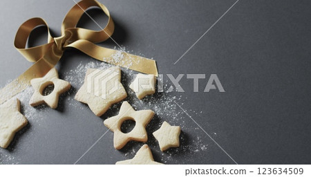 Golden ribbon adorns star-shaped cookies on a dark surface 123634509