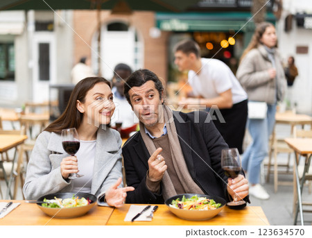 European couple sitting on the terrace of the restaurant and chatting 123634570