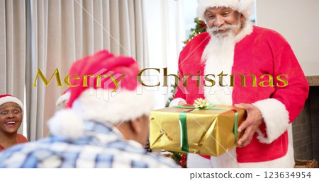 Image of merry christmas text over diverse senior friends with santa at christmas at home 123634954