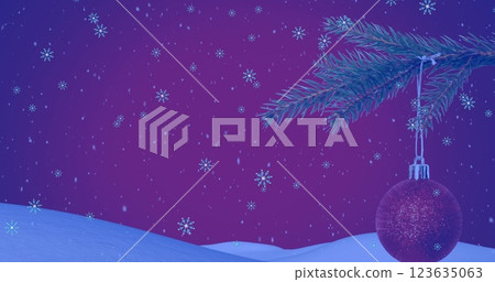 Image of snow falling over christmas tree with red bauble in winter scenery 123635063