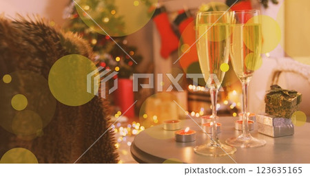 Image of yellow spots of light over new year glasses of champagne and christmas tree Image of yellow spots of light over new year glasses of champagne and christmas tree 123635165