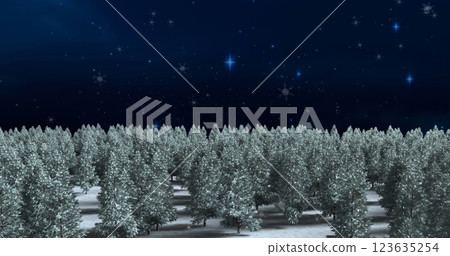 Snow falling over multiple trees on winter landscape against shining stars on blue background 123635254