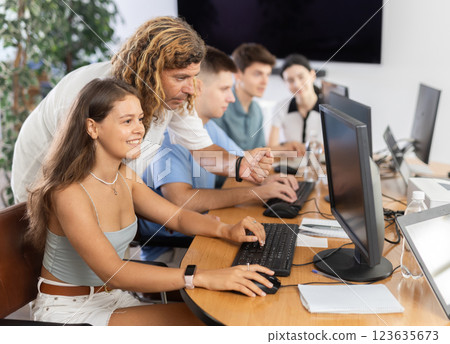 Young female trainee working at IT startup with male mentor 123635673