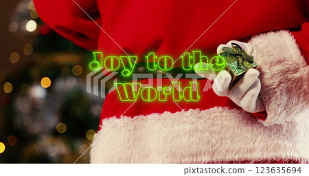 Image of neon green joy to the world text banner over santa claus decorating a christmas tree Image of neon green joy to the world text banner over santa claus decorating a christmas tree 123635694
