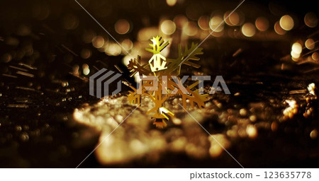 Image of golden snowflake rotating over liquid falling on ground Image of golden snowflake rotating over liquid falling on ground 123635778