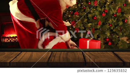 Digital composite of Wooden foreground with Santa bringing gifts to Christmas tree Digital composite of Wooden foreground with Santa bringing gifts to Christmas tree 123635832