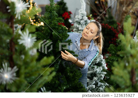 Woman choosing christmas tree for home Woman choosing christmas tree for home 123635927