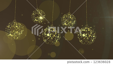 Image of gold christmas baubles swinging over stars and light spots on brown background 123636028