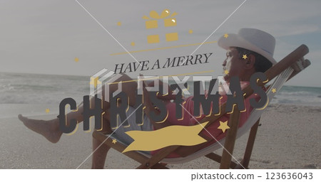 Image of have a merry christmas over senior hispanic man sunbathing with book on beach 123636043