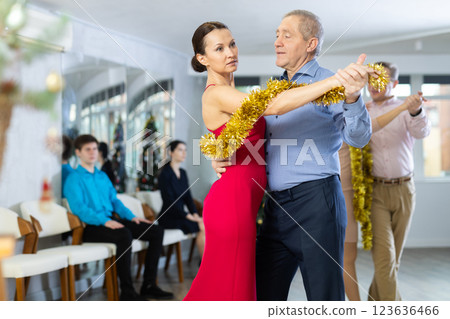 Couples dancing during Christmas - men and women dancing tango or samba next to Christmas tree Couples dancing during Christmas - men and women dancing tango or samba next to Christmas tree 123636466