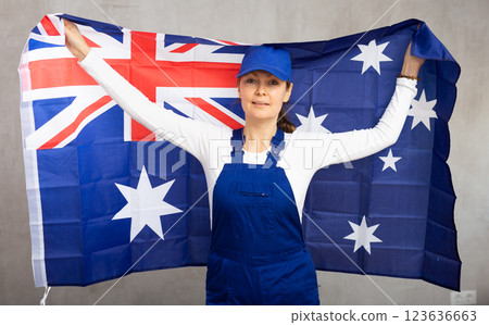 Cheerful female worker with wide grin on her face holding flag of australia 123636663