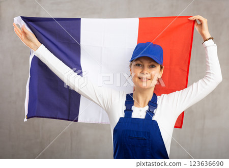 Smiling adult woman in uniform holding France flag Smiling adult woman in uniform holding France flag 123636690