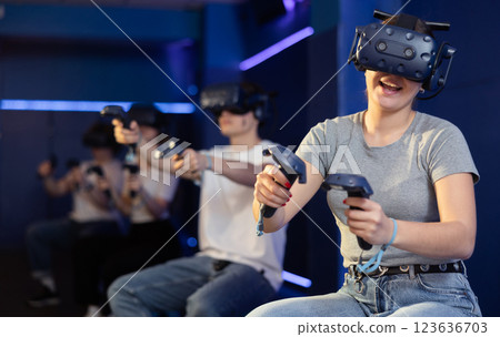 girl in virtual reality glasses controls superhero with joystick in exciting action game simulator 123636703