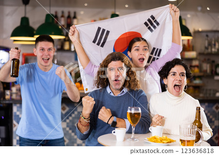 Group of happy friends with flag of South Korea celebrating victory of their favorite team in beer bar 123636818