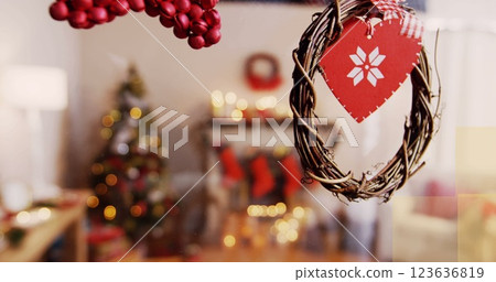 Heart-shaped wreath hanging on glass, highlighting Christmas decor Heart-shaped wreath hanging on glass, highlighting Christmas decor 123636819