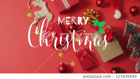 Image of merry christmas over presents and decorations on red surface Image of merry christmas over presents and decorations on red surface 123636840