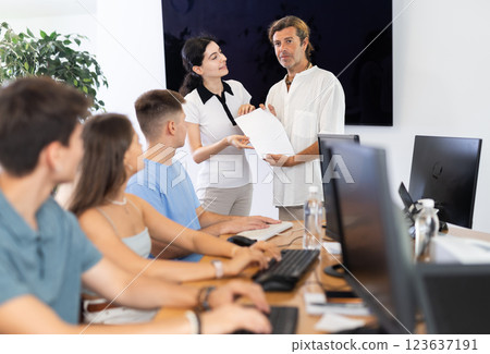 Male manager of IT startup giving contract to young woman 123637191