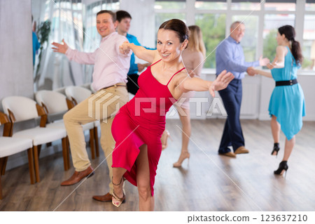 Enthusiastic woman learning dynamic dances with partner at choreography class Enthusiastic woman learning dynamic dances with partner at choreography class 123637210