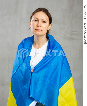 Sad worried woman tensely displaying ukrainian flag Sad worried woman tensely displaying ukrainian flag 123637251