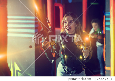 Young lady having fun playing lasertag in arena Young lady having fun playing lasertag in arena 123637385