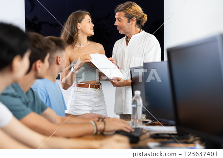 Iinstructor handling certificate to female student completing computer course Iinstructor handling certificate to female student completing computer course 123637401