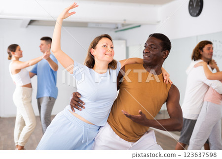 Woman and man practicing modern dance moves in pair during group class Woman and man practicing modern dance moves in pair during group class 123637598