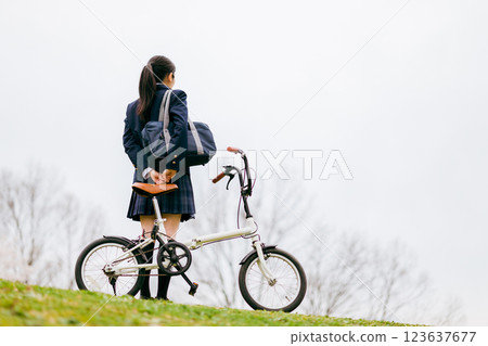 Junior and senior high school girls in uniforms cycling to school (meeting) Junior and senior high school girls in uniforms cycling to school (meeting) 123637677