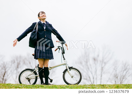 Junior high and high school girls in uniforms commuting to school by bicycle 123637679