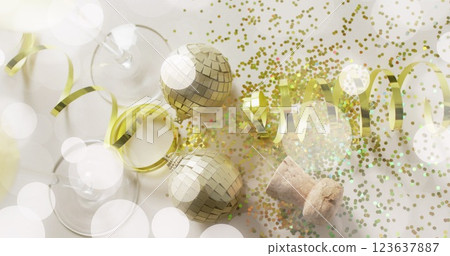 Image of spots of light over gold confetti and champagne glasses Image of spots of light over gold confetti and champagne glasses 123637887
