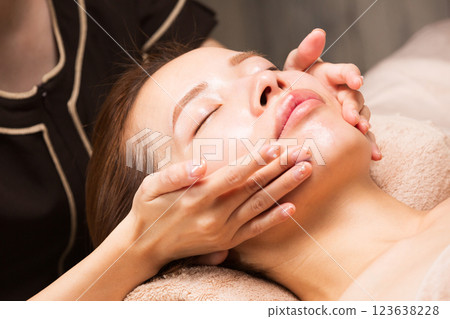 年輕的亞洲女性正在接受臉部按摩。 123638228