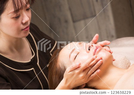 年輕的亞洲美容師正在做臉部按摩。 123638229