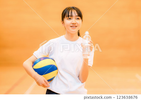 身著運動服的女國中生和高中生在體育館打排球，運動時補充水分 123638676