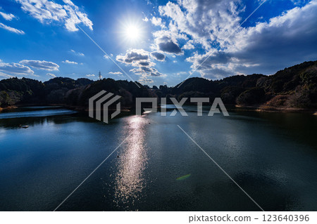 The temperature is rising and it's starting to feel like spring at Nara Nunome Dam. The beautiful lake surface reflects the clouds floating in the blue sky. The temperature is rising and it's starting to feel like spring at Nara Nunome Dam. The beautiful lake surface reflects the clouds floating in the blue sky. 123640396