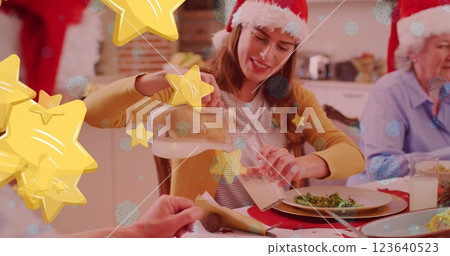 Image of stars over caucasian family with santa hats having christmas dinner Image of stars over caucasian family with santa hats having christmas dinner 123640523
