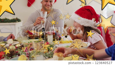 Image of stars over caucasian family with santa hats having christmas dinner 123640527