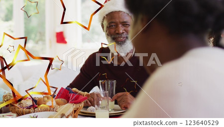 Image of stars over african american family with santa hats having christmas dinner Image of stars over african american family with santa hats having christmas dinner 123640529