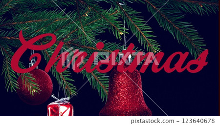 Image of christmas text banner over hanging decorations on a branch against black background 123640678