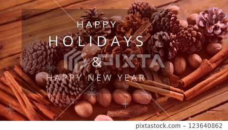 Image of merry christmas text banner over pine cones and cinnamon sticks on wooden surface 123640862