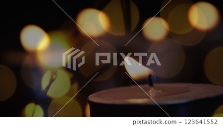 Image of lit candle with flickering fairy lights 123641552