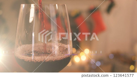 Image of red wine being poured into glass over christmas stockings Image of red wine being poured into glass over christmas stockings 123641577