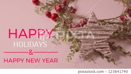 Image of happy holidays and text banner over red cherries and star decoration on pink surface 123641740