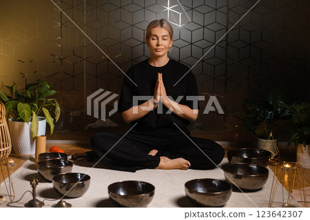 Practice of mindfulness and meditation with sound bowls in a serene indoor space during a wellness session Practice of mindfulness and meditation with sound bowls in a serene indoor space during a wellness session 123642307